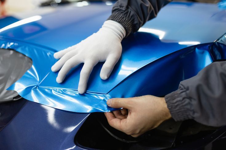 car,wrapping,specialist,putting,vinyl,foil,or,film,on,car.